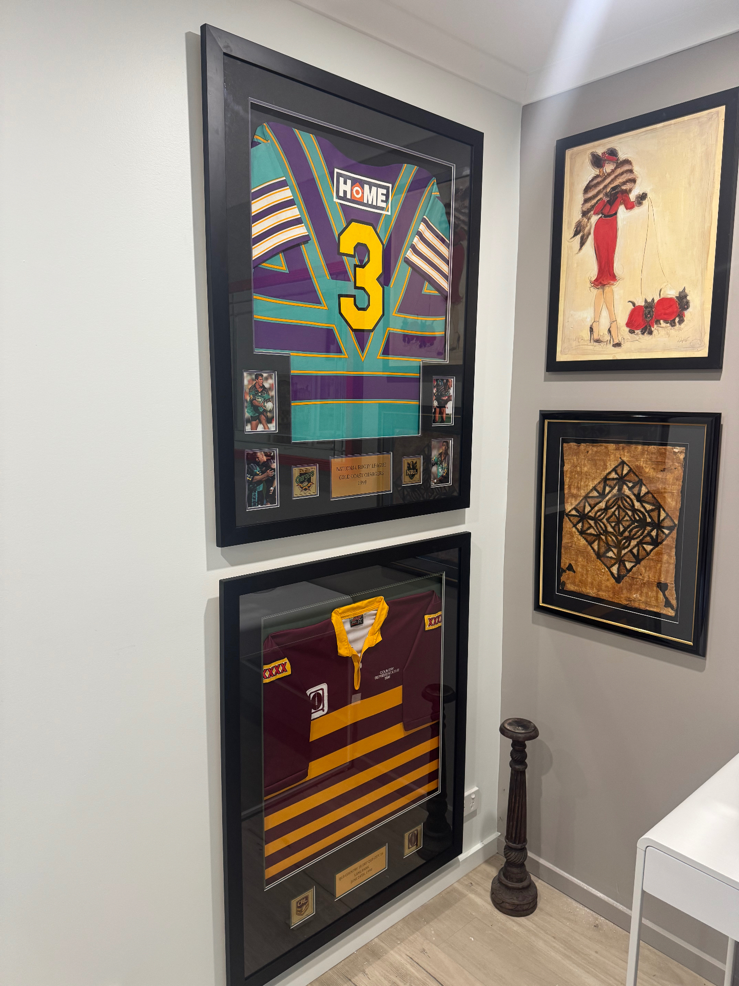 Framed sports jerseys and artwork on studio wall